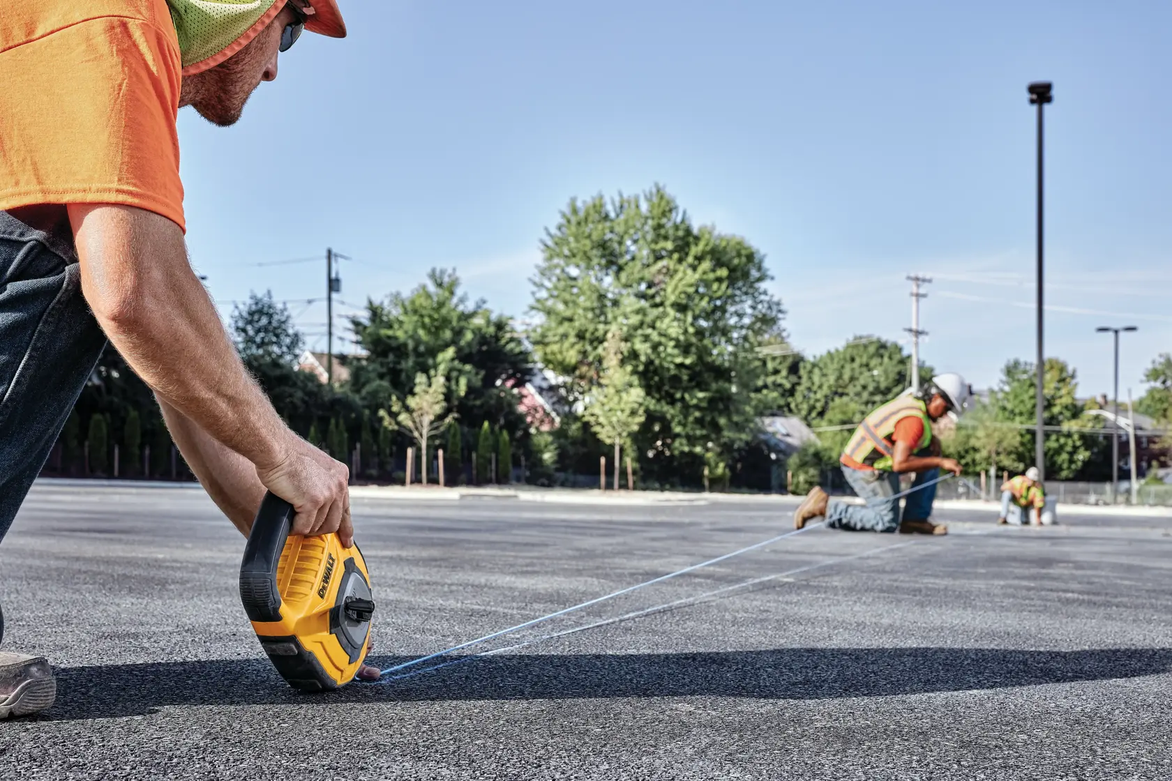 150 feet Large Capacity Chalk Reel being used by workers to mark road outdoors.